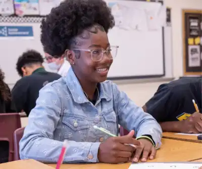 A JA student smiling at a volunteer